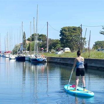 Glisse douce entre pontons et parcs à huîtres, vue reculée sur le village.